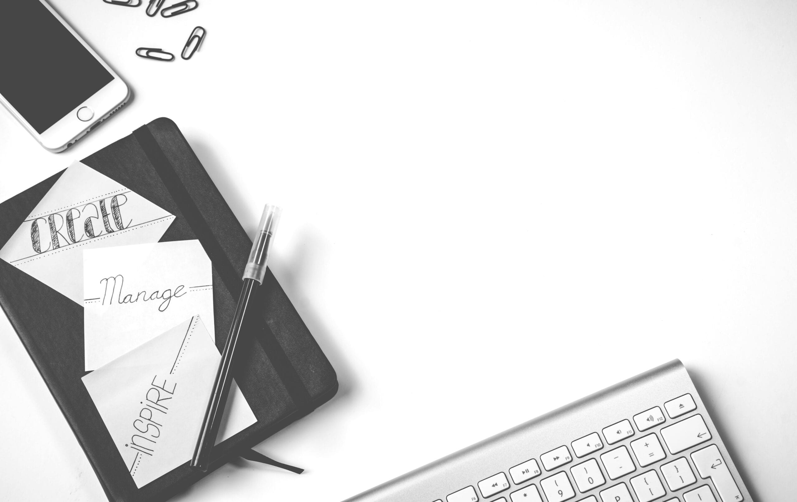 Professional business owner multitasking with phone and laptop at desk.